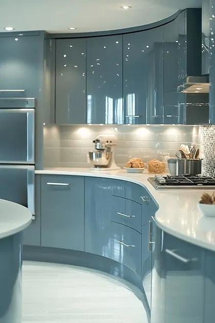 Blue-grey kitchen with curved gloss cabinets, a light glass backsplash and recessed lighting.